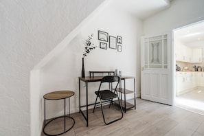 A modern kitchen with white cabinets, a wooden countertop, and a dining area with a table and chairs.
