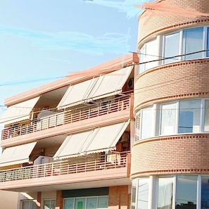 Un edificio de varios pisos con balcones y ventanas amplias.