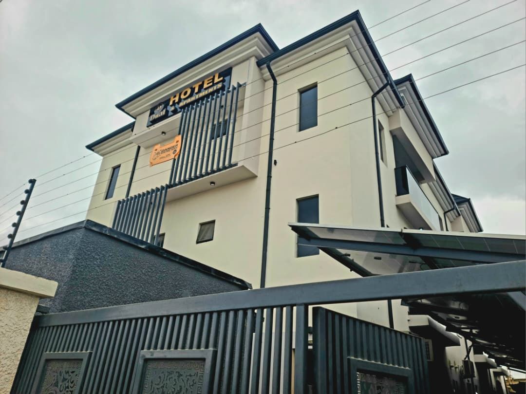 Un hôtel au design moderne, doté d’une enseigne bien visible et d’une entrée sécurisée par un portail.