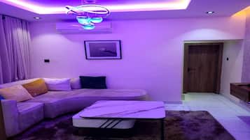 Una sala de estar moderna con un sofá modular, una mesita y una lámpara de techo.