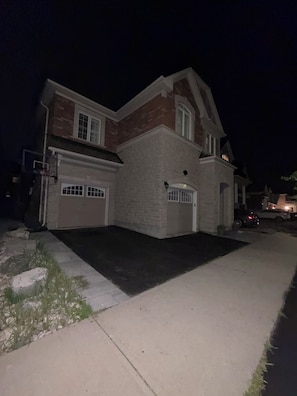 Ein zweistöckiges Haus mit Garage und Auffahrt.