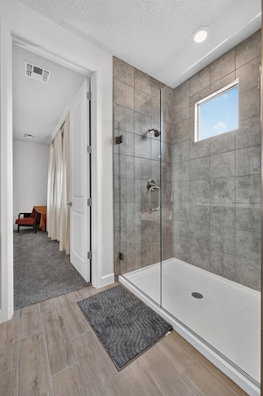 Un baño moderno con cabina de ducha de vidrio, inodoro a la vista y ducha.