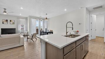 A modern apartment with a kitchen, dining area, and living room.