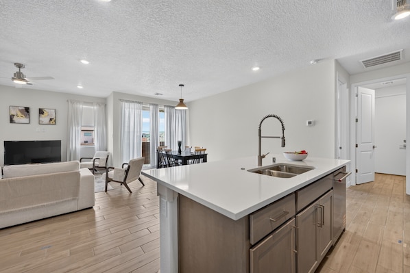 A modern apartment with a kitchen, dining area, and living room.