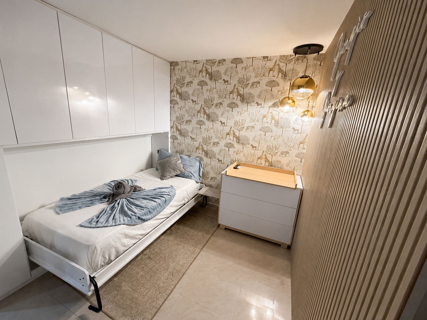 A compact bedroom with a bed, bedside table, and wardrobe.