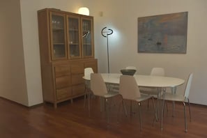 A dining area with a wooden cabinet, a white table, and chairs. - Casa Milton Garden, a spacious home with own garden in the center of Florence (Firenze)