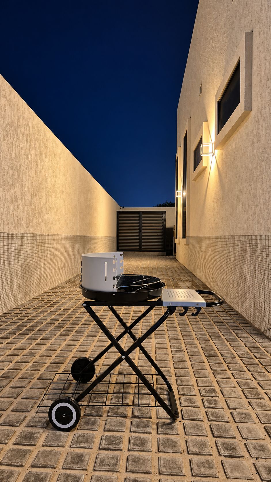 A courtyard with a table, a white appliance, and a wheelbarrow.