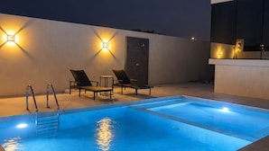 A rooftop pool with a clear blue water surface, surrounded by lounge chairs and a modern architectural design. - Azure 88 - Heated Private Pool Villa near Jebel Jais (Ras Al-Khaimah)