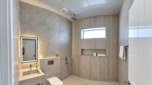 A modern bathroom with a built-in sink, a toilet, a vanity with a mirror, and a shower area. - Azure 88 - Heated Private Pool Villa near Jebel Jais (Ras Al-Khaimah)