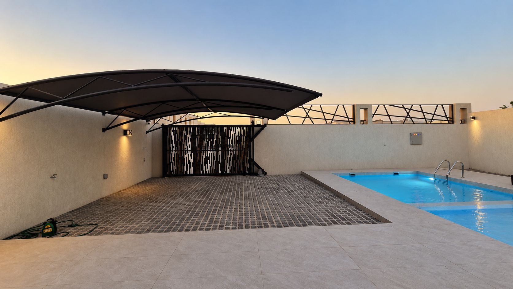Ein Poolbereich auf dem Dach mit überdachter Lounge-Ecke und Schwimmbecken.