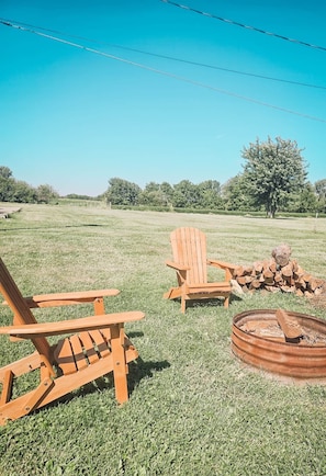 An outdoor seating area with wooden chairs and a fire pit.