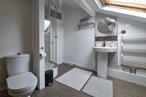 Une salle de bain moderne équipée de toilettes, d’une douche, d’un lavabo et d’un miroir.