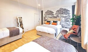 Une chambre d’hôtel avec un lit, une chaise, un miroir et une grande fenêtre.