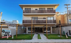 A two-story residential building with a covered parking area and a visible signboard. - Apt With Balcony 90m From Riacho Beach Bal0101 (São Miguel dos Milagres)