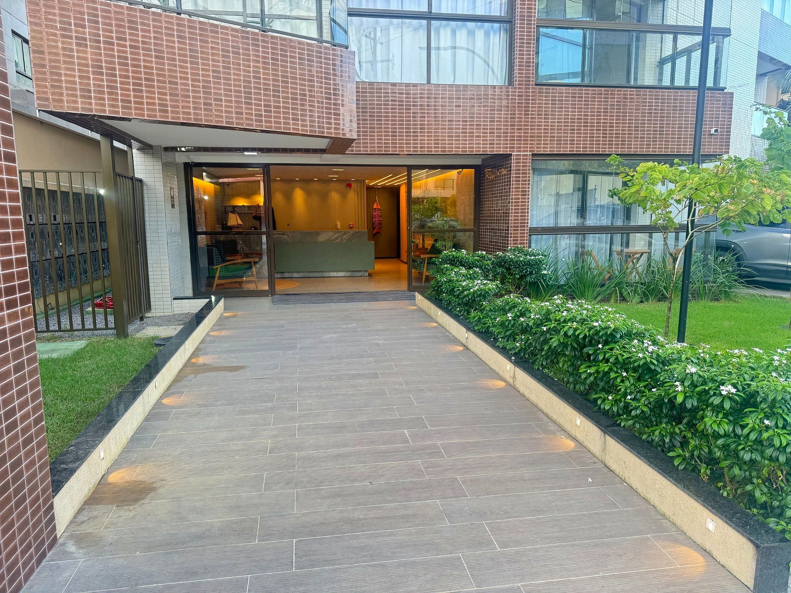 Una entrada de edificio con un camino empedrado que lleva a una zona de recepción.