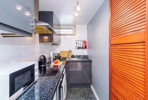 Cocina compacta con microondas, tostadora y lavamanos.