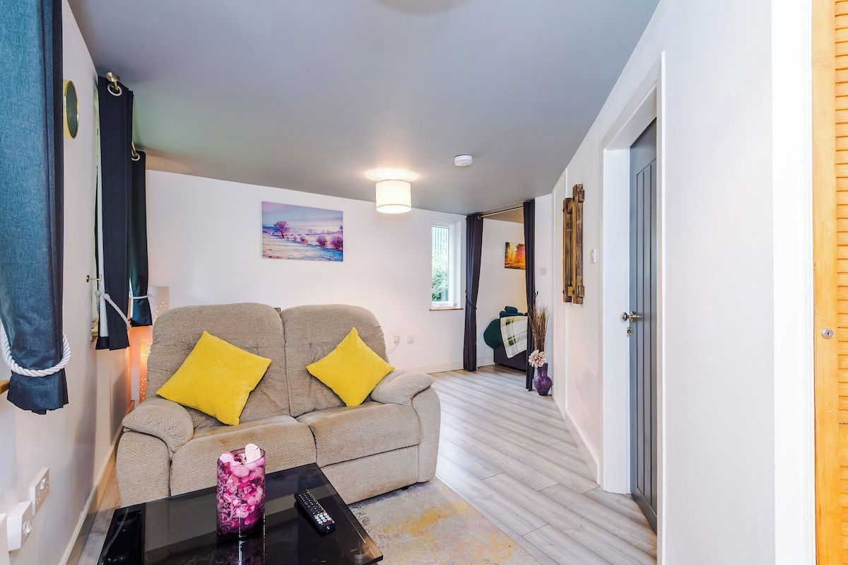A modern living room with a sofa, a coffee table, and a painting on the wall.