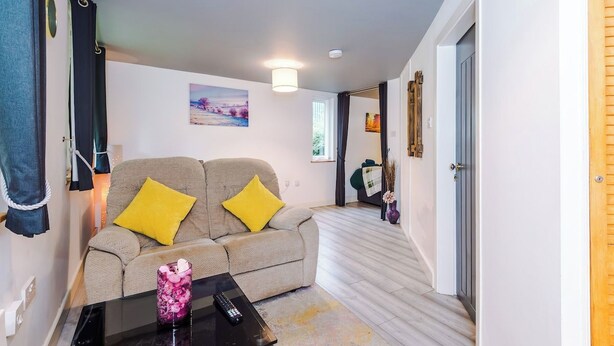 Ein modernes Wohnzimmer mit einer Couch, einem Couchtisch und einem Bild an der Wand.