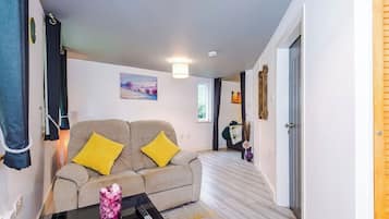 A modern living room with a sofa, a coffee table, and a painting on the wall.