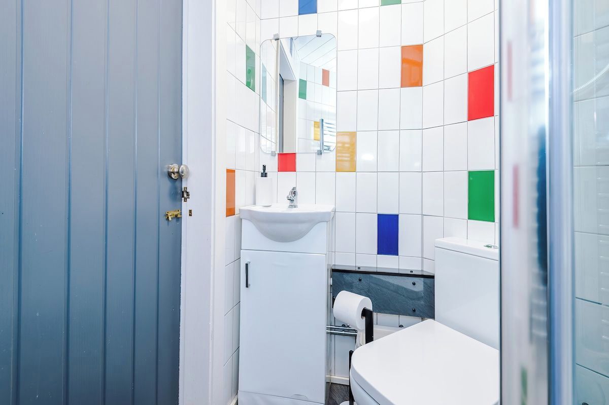 A bathroom with a sink, mirror, and toilet.