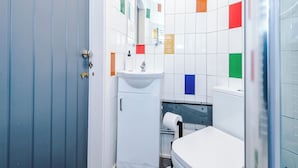 Ein Badezimmer mit Waschbecken, Spiegel und Toilette.