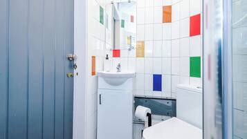 A bathroom with a sink, mirror, and toilet.