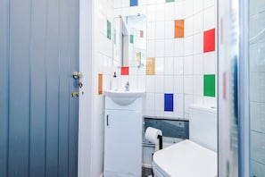 A bathroom with a sink, mirror, and toilet. - Stylish 1-Bed Apartment in Wigan | Free Parking (Greater Manchester)