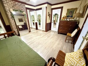 A room with a bed, a dresser, a chair, and a mirror.