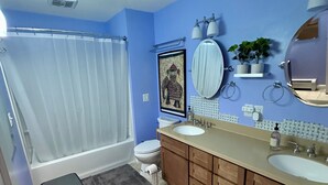 Ein Badezimmer mit Badewanne, Toilette, Waschtisch und Spiegel.