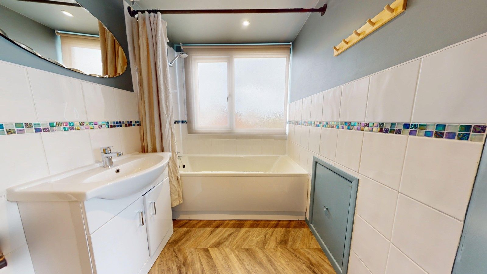 A bathroom with a bathtub, a sink, and a shower curtain.