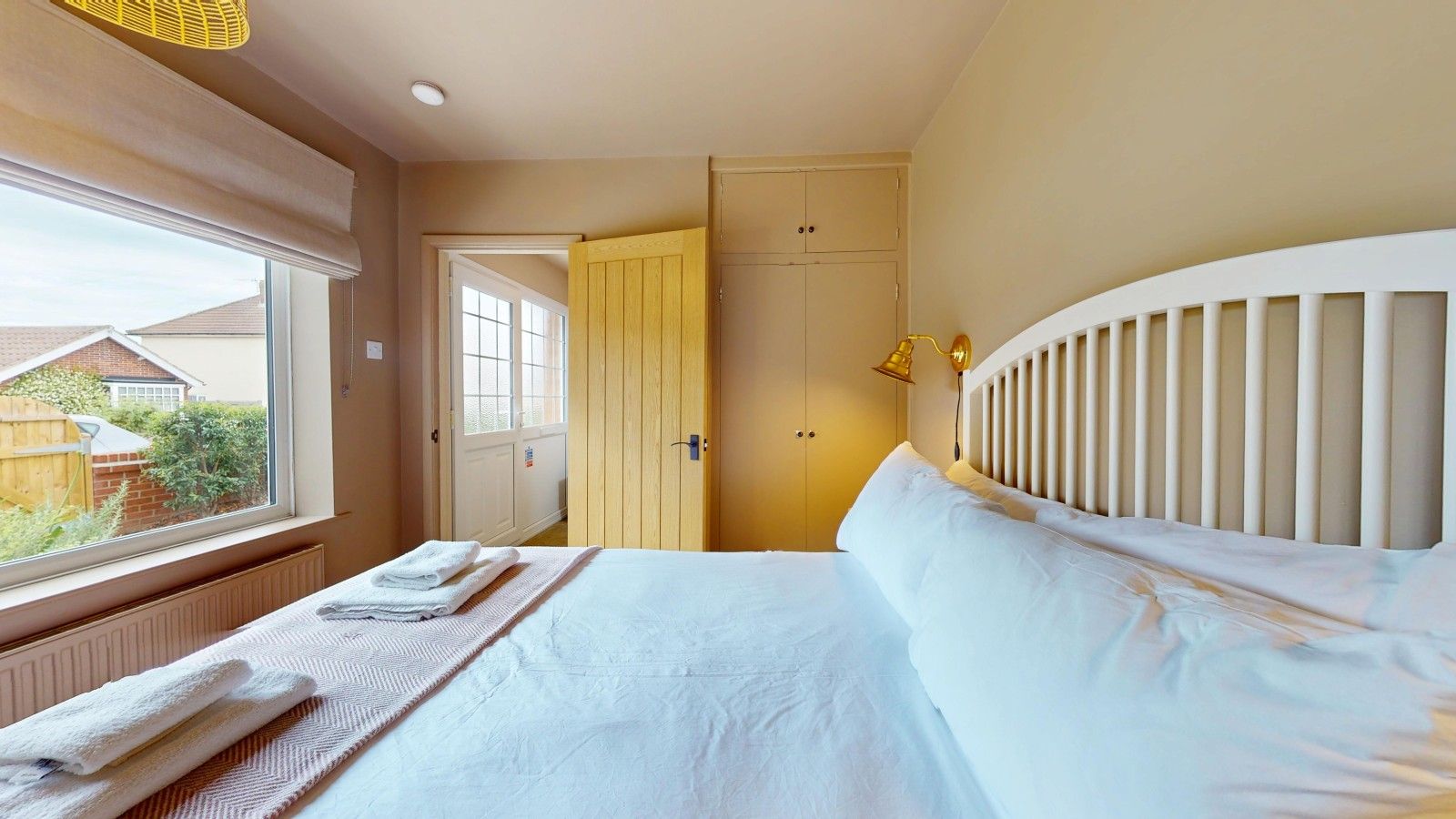 Une chambre d’hôtel avec un lit, une fenêtre, une porte et une vue sur l’extérieur.