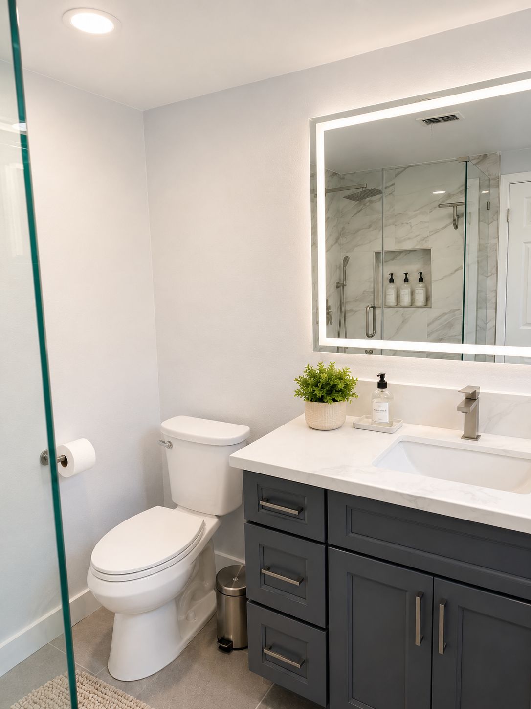 A modern bathroom with a toilet, sink, and mirror.