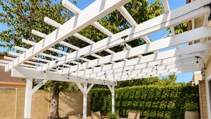 An outdoor patio with a pergola, a barbecue grill, and a dining table with chairs. - Spacious 5-bedroom house in terrific Cypress with BBQ (Cypress)