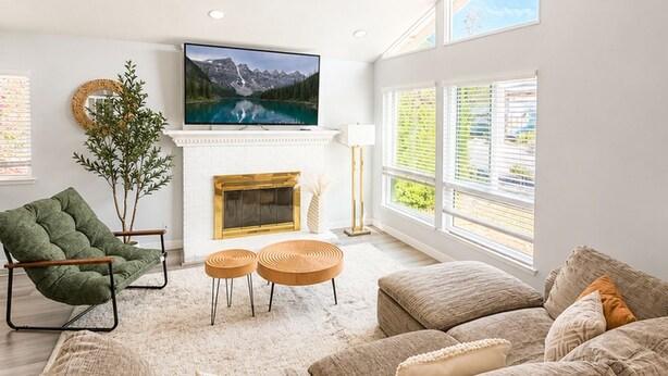 A modern living room with a fireplace, comfortable seating, and large windows. - Spacious 5-bedroom house in terrific Cypress with BBQ (Cypress)