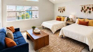A modern bedroom with two beds, a sofa, and a coffee table. - Spacious 5-bedroom house in terrific Cypress with BBQ (Cypress)