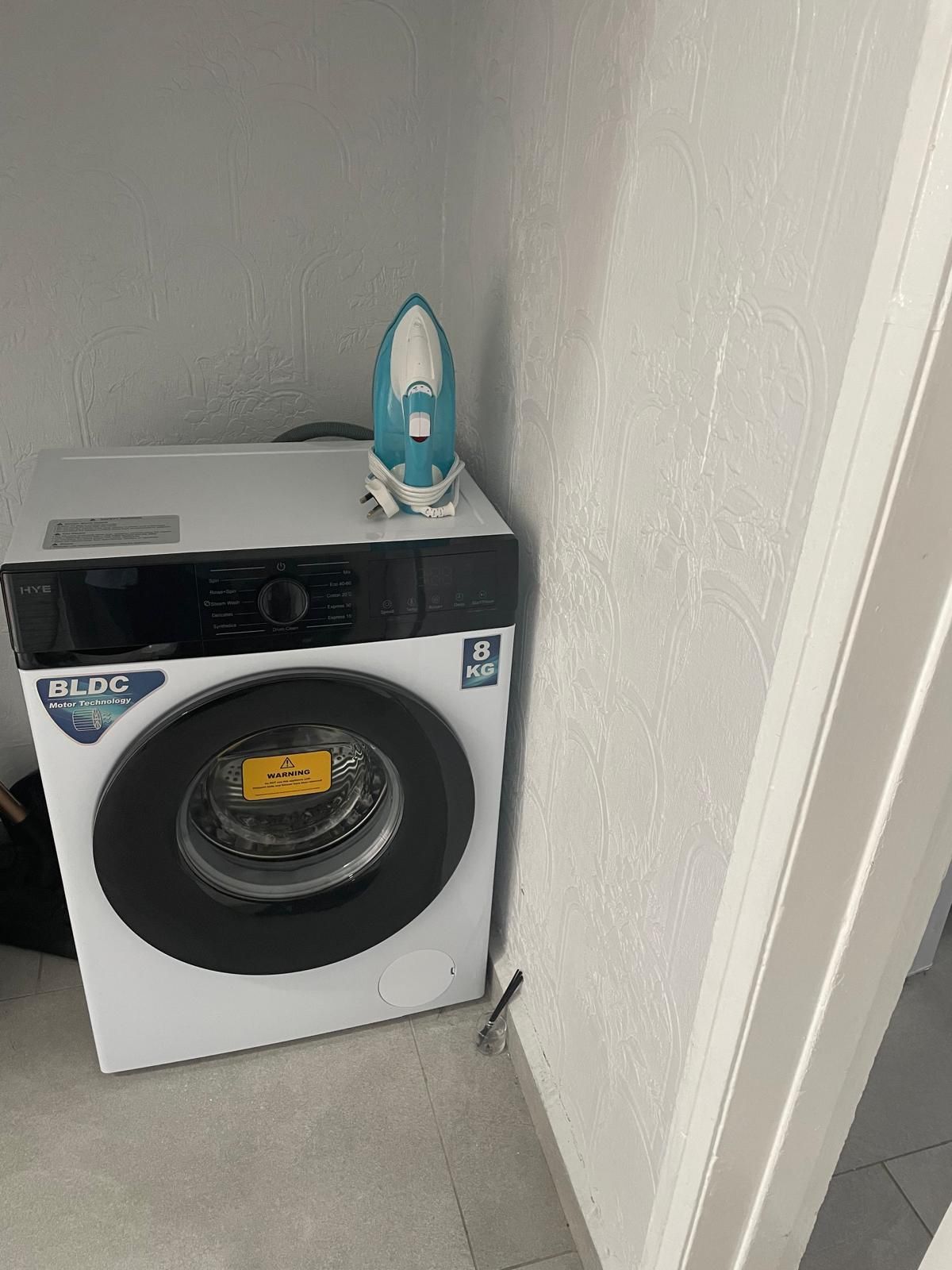 A front-loading washing machine with a BLDC motor, a warning label, and a capacity of 8 kg.