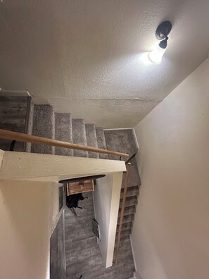Eine Treppe mit hölzernem Geländer und einer Wandleuchte.