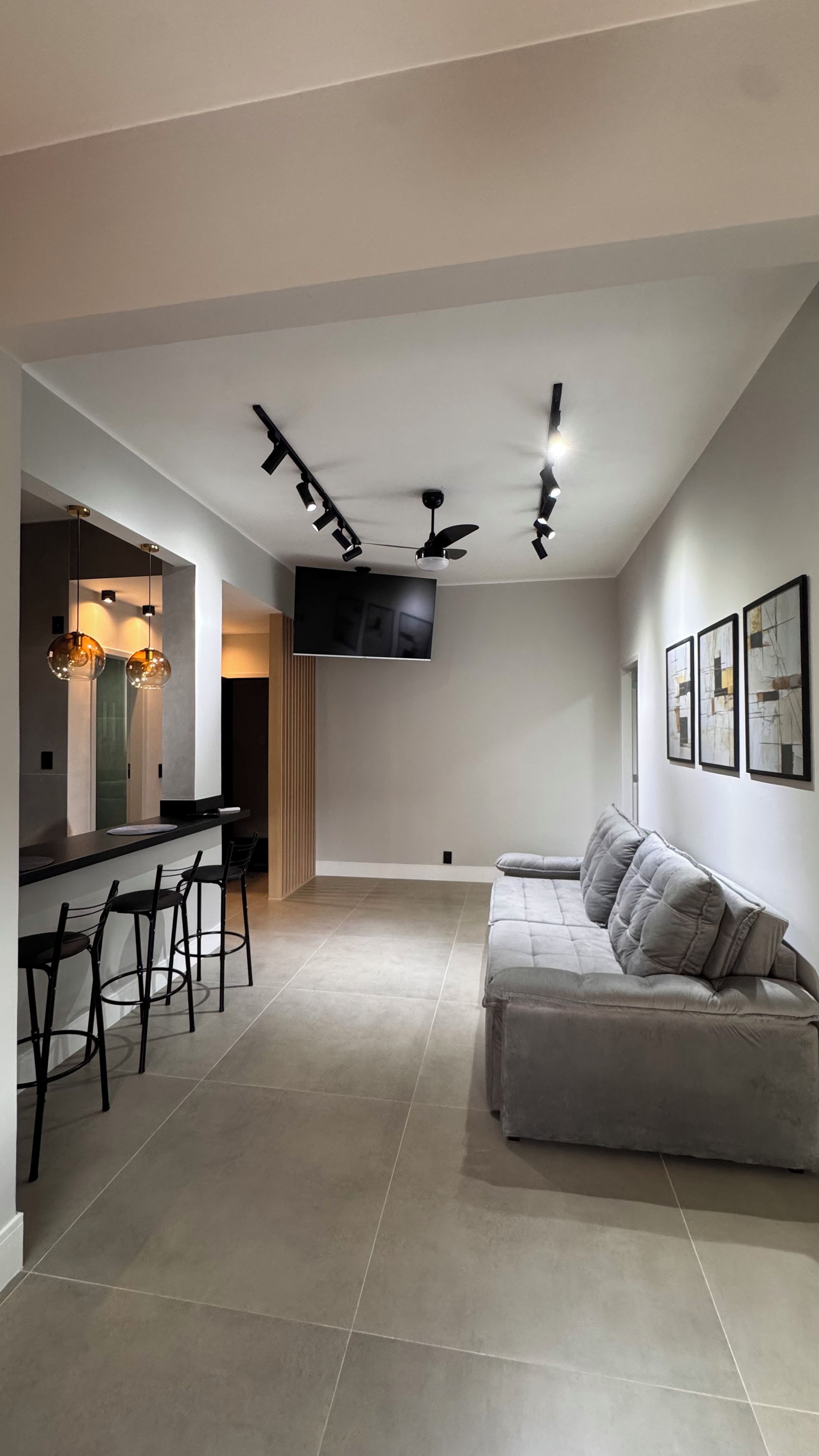 A modern living space with a sofa, dining area, and kitchen.