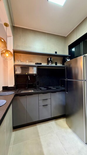 A modern kitchen with a built-in stove, a stainless steel refrigerator, and a coffee maker on the countertop. - Lapa RJ Space | 1.5km to Flamengo Beach (Rio de Janeiro)