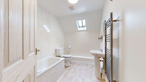 A bathroom with a bathtub, toilet, and sink. - Newly Refurbished 2-Bed Retreat in Aylsham – Perfect for Exploring North Norfolk (Aylsham)