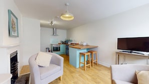 A compact living space with a kitchenette, a sofa, a television, and a fireplace. - Newly Refurbished 2-Bed Retreat in Aylsham – Perfect for Exploring North Norfolk (Aylsham)