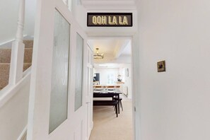 Un corridoio che conduce a una sala da pranzo con un cartello che riporta la scritta 'OOH LA LA'.