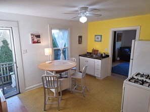 A compact kitchen with a dining table, chairs, a ceiling fan, and a refrigerator. - Peaceful 2-bedroom house in  Evanston. (Evanston)