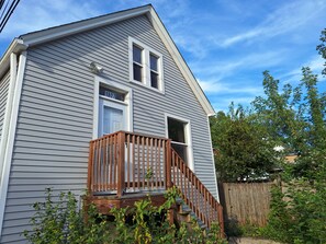 A two-story house with a wooden front porch and a visible number '1607' on the door. - Peaceful 2-bedroom house in  Evanston. (Evanston)
