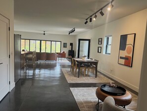 Un salón amplio con mesa de comedor, sillas y chimenea.