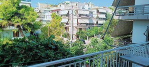 A residential area with multiple buildings, some with balconies, and lush greenery in the foreground. - Candy Studio Marousi (Marousi)