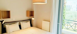 Ein Schlafzimmer mit Bett, Nachttischlampen, einem Fenster mit Blick und einer Heizung.
