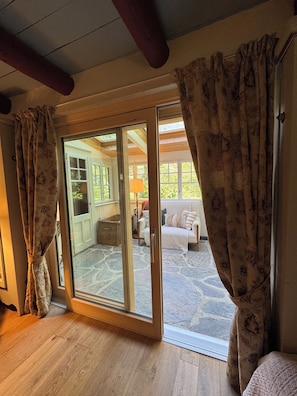 A room with a wooden floor, a sliding glass door leading to an outdoor patio, and a view of the outside. - Comfortable chalet for nature lovers - near Portes du Soleil skiing area (Val-d'Illiez)