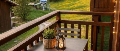 Ein Balkon mit Tisch, Stühlen und einer Laterne.