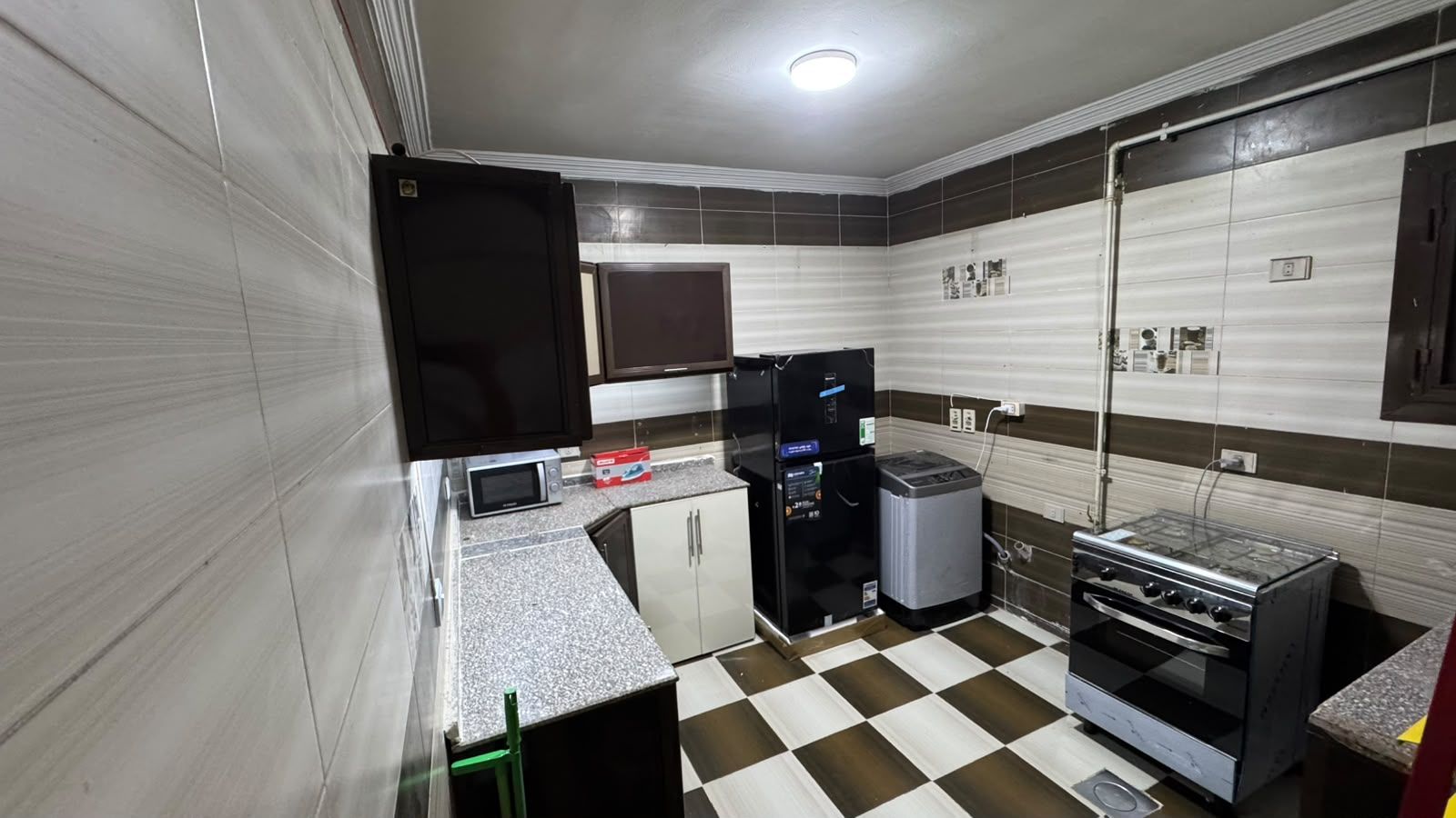 A compact kitchen with a microwave, refrigerator, and stove.
